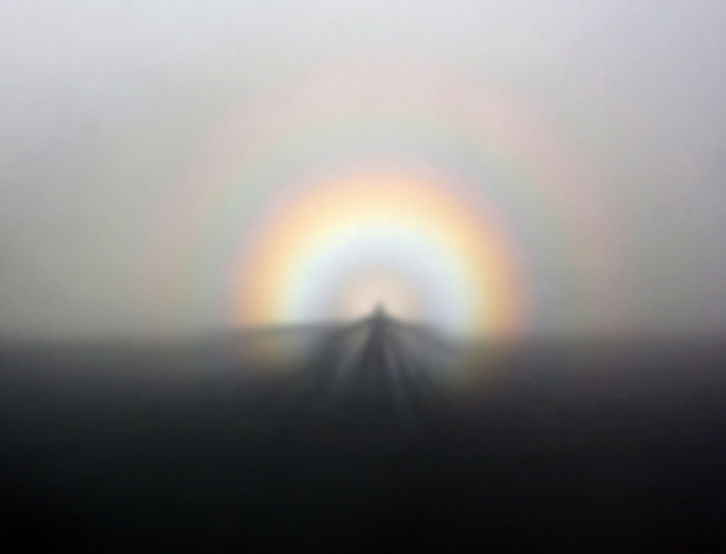 Broken Spectre, a double rainbow wrapped around a person's silhouette